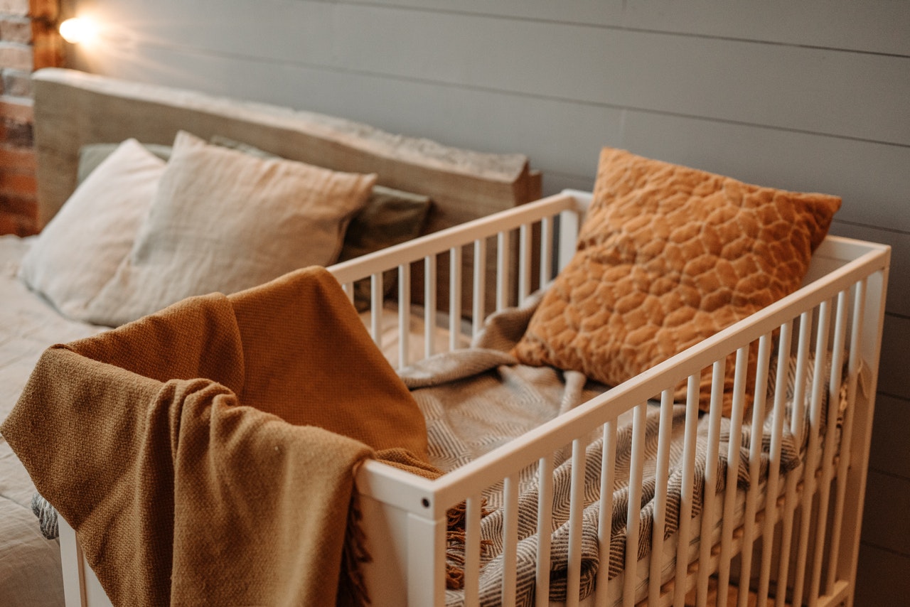 łóżeczko niemowlęce z kocem i poduszką